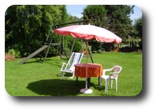 Garden with deck chair, parasol and swing